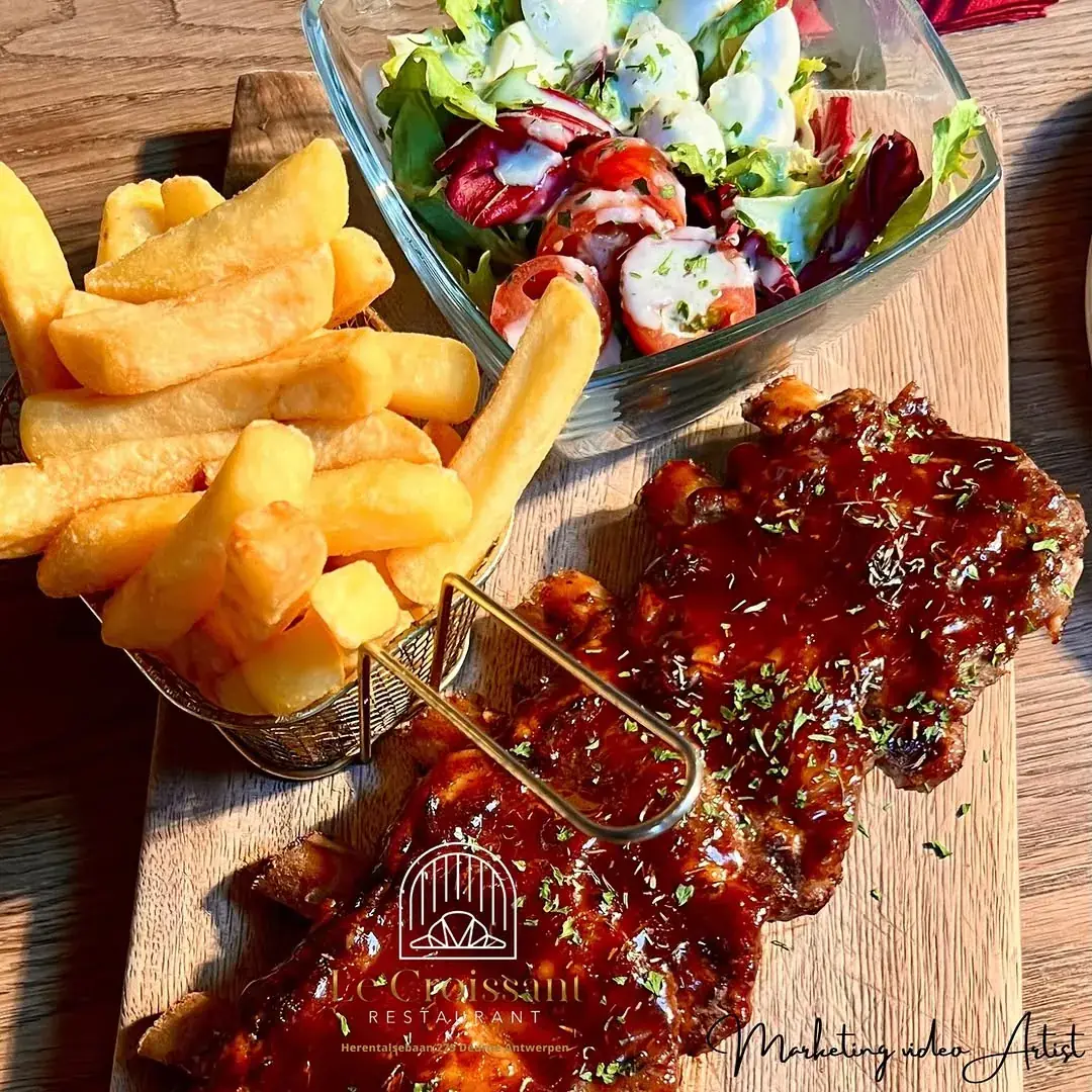 Spare ribs met barbecuesaus, verse frieten en salade op een houten plank